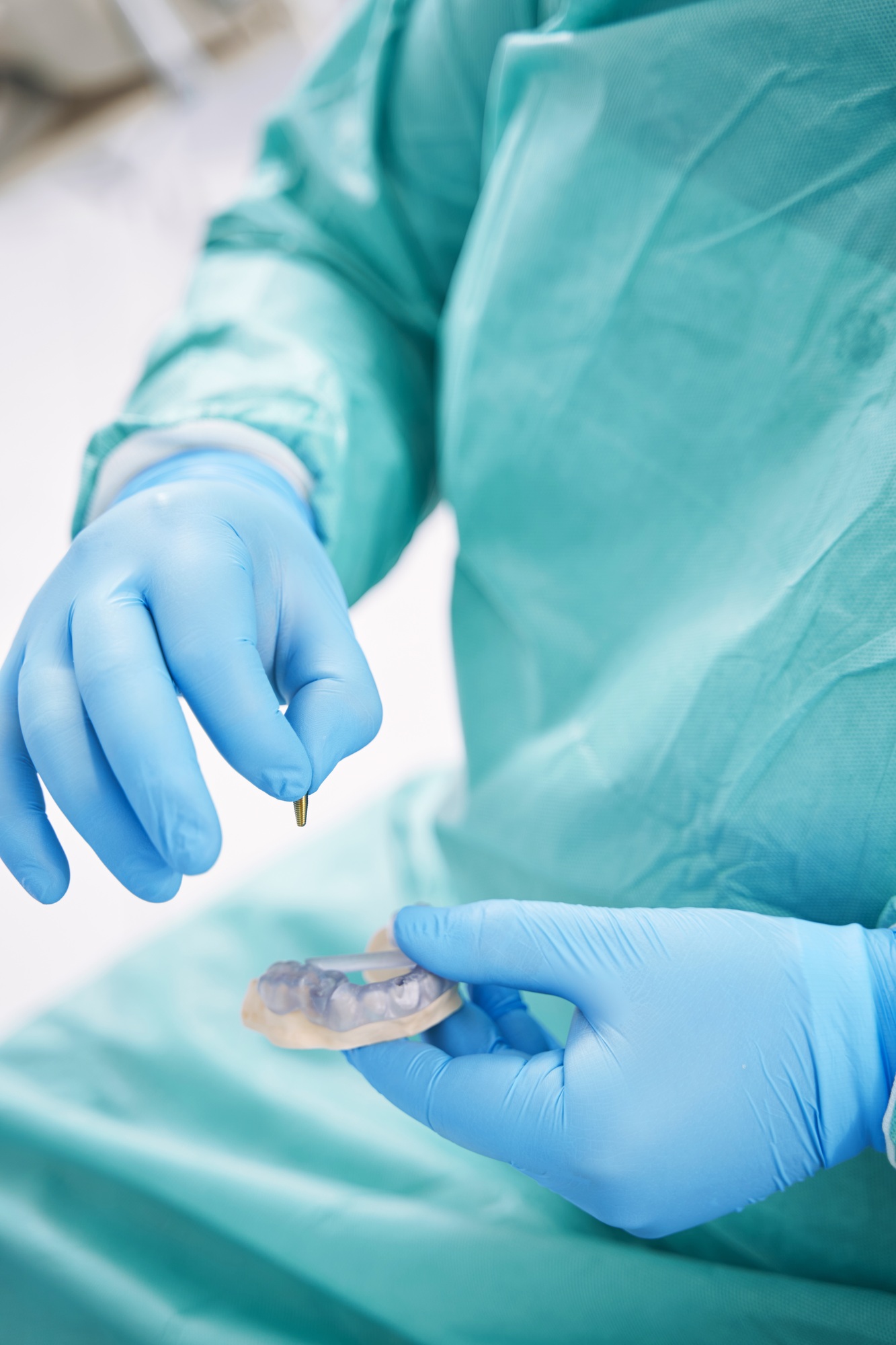 Dentist holding teeth model and dental implant